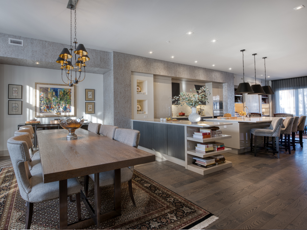 Renovated dining room and kitchen in open space with brown hardwood floors.