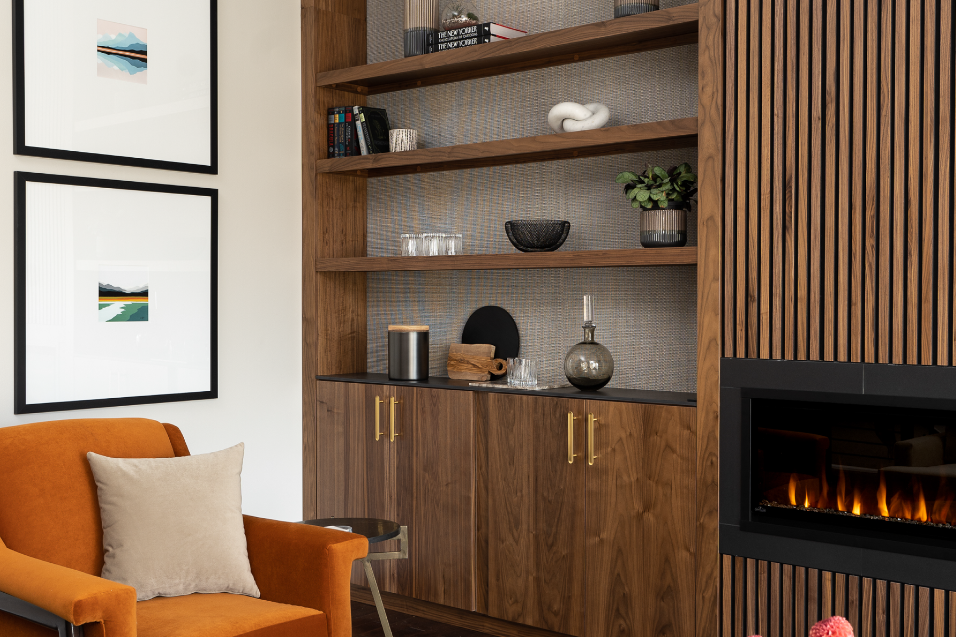 A black fireplace with fluted paneling and modern shelving.