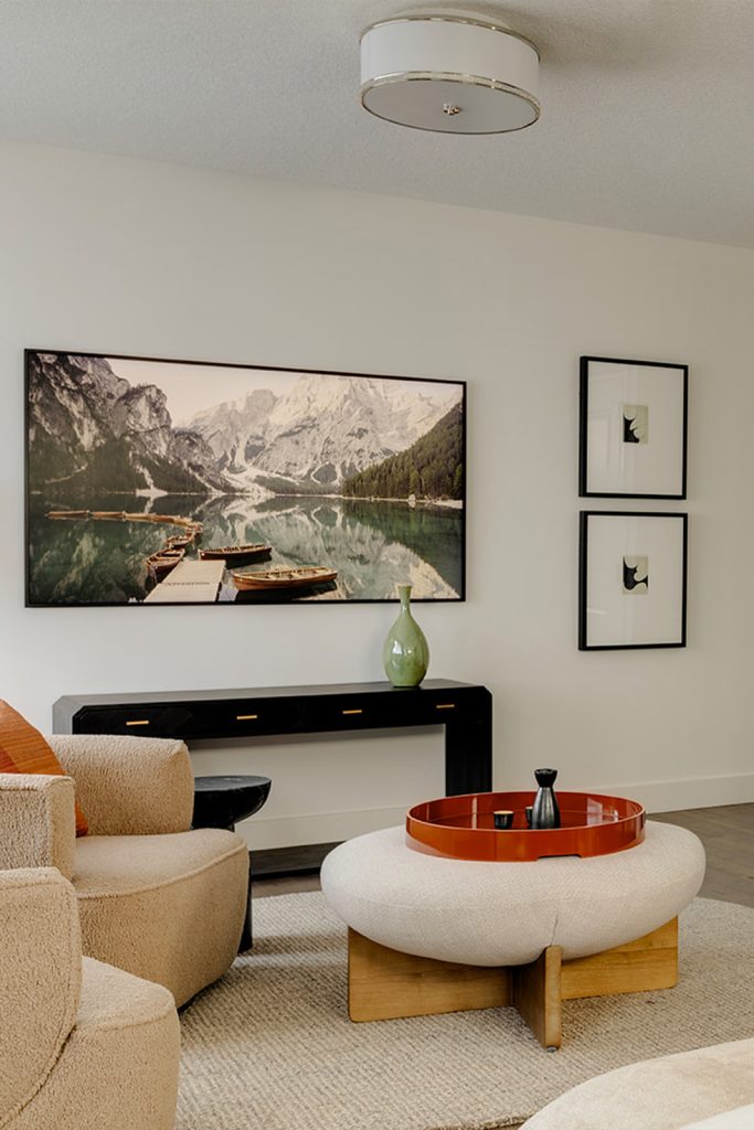 A primary bedroom with art of the mountains and modern decor.