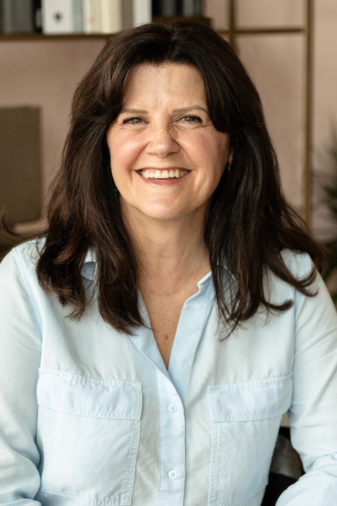 A professional headshot of a woman in an interior design office.