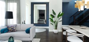 A modern room designed with off white furniture and dark blue accents.