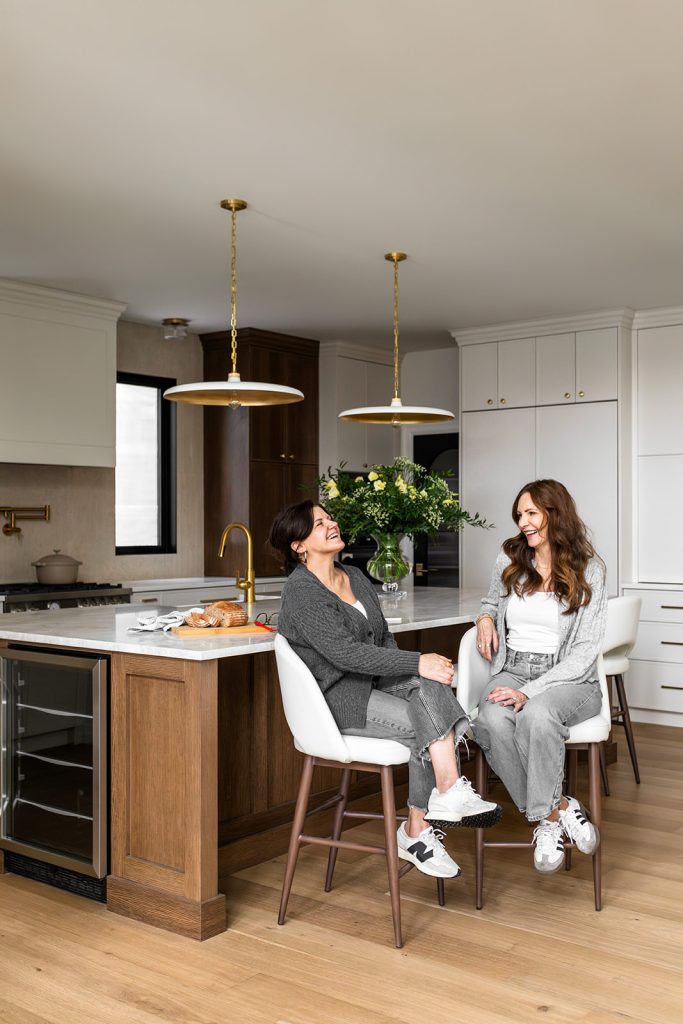 Two interior designers celebrating in their clients new kitchen.